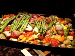This pan of roasted veggies is a little too full to go into the oven and should be broken down into two batches of a single layer each.