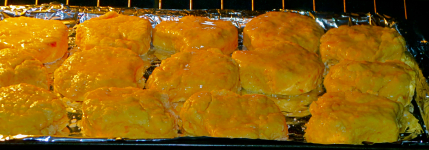 Biscuits rising in the oven basted with melted butter.